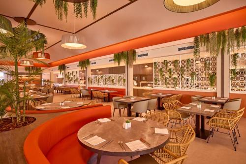 a restaurant with tables and chairs and plants at Zafiro Can Picafort in Can Picafort