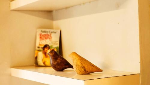 two figurines sitting on a shelf with a book at LiveAway Mukteshwar, Nainital by PACK in Mukteswar