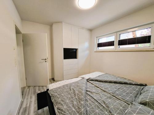 a bedroom with two beds and a tv and two windows at Ferienhaus "Laila" ID 16019-2 in Möllenhagen