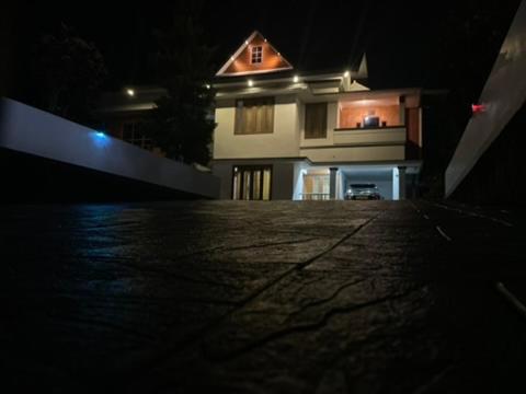 Una casa iluminada por la noche en frente en Zion Apostolate, en Athirappilly