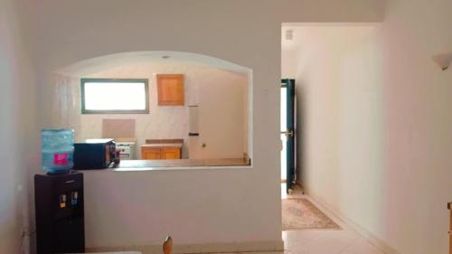 a room with a kitchen with a window and a refrigerator at Romantic Chalete قرية الغرندل in Ras Sedr