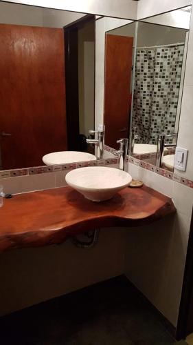 a bathroom with a sink and a large mirror at El Quebrachal Del Monte in Capilla del Monte
