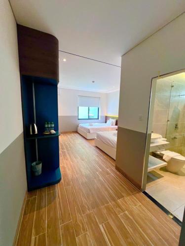 a bedroom with a bed and a glass wall at Hoàng Khang Hotel- Khách Sạn Buôn Ma Thuột in Buôn Kô Sir