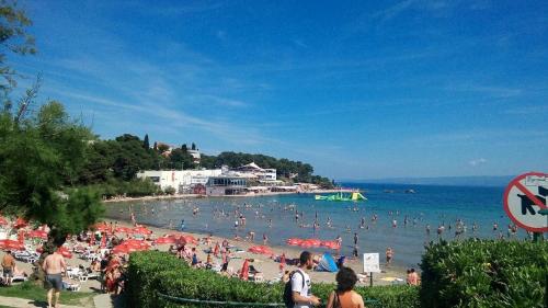 una multitud de personas en una playa con sombrillas en Apartment Iva en Split