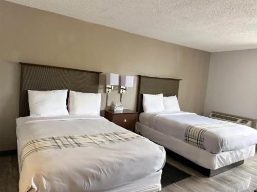 a hotel room with two beds with white pillows at Motel 6 Rochester - Airport in Rochester