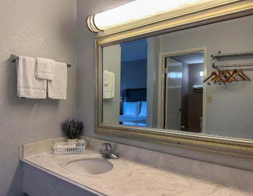 a bathroom with a sink and a large mirror at Motel 6 Rochester - Airport in Rochester