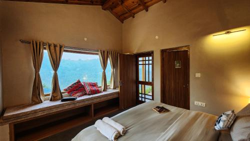 a bedroom with two beds and a large window at LiveAway Mukteshwar, Nainital by PACK in Mukteswar