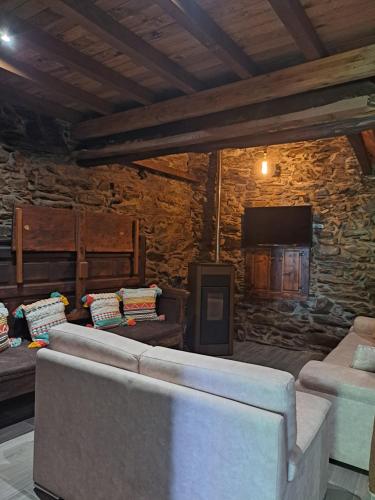 a living room with two couches and a stone wall at Casa Dos Avós - Alojamento Local in Bragança