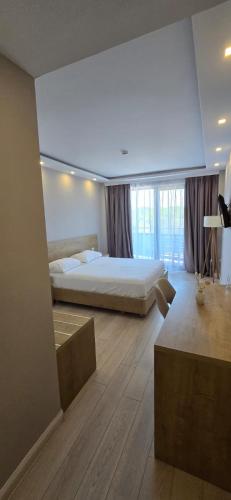 a large bedroom with a bed and a large window at Amber Hotel Albania in Spille