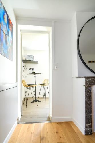 - un couloir avec une salle à manger dotée d'une table et d'un miroir dans l'établissement Studio Cosy à Fontainebleau, à Fontainebleau