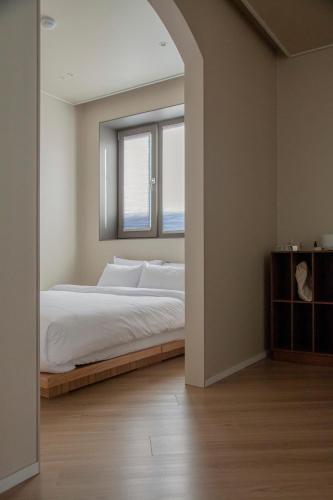 a bedroom with a large bed and a window at Stay Dooroo in Suncheon