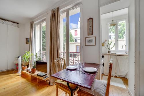eine Küche und ein Wohnzimmer mit einem Holztisch in der Unterkunft Appartement Romantique à Saint-Ouen in Saint-Ouen