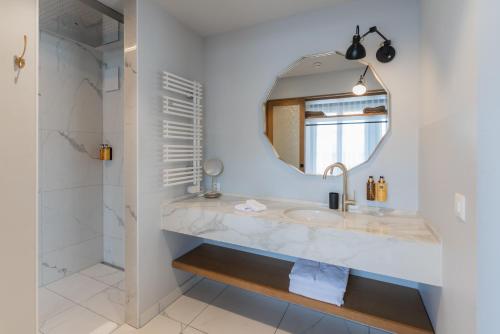 a bathroom with a sink and a mirror at Boutique Hotel Glacier in Grindelwald