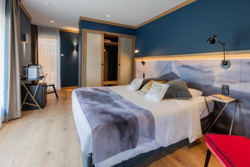 a bedroom with a large bed with a blue wall at Boutique Hotel Glacier in Grindelwald
