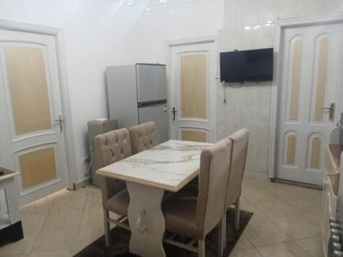 eine Küche mit einem Tisch und Stühlen sowie einem TV in der Unterkunft Chalet 3 VILLA114 first floor 2bed rooms and 2 bathrooms sea view green beach in El-Alamein
