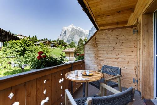 a patio with a table and chairs on a balcony at Boutique Hotel Glacier in Grindelwald