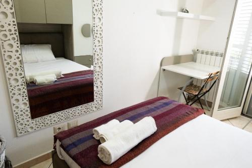 a bedroom with a mirror and a bed with towels at Marconi House - Appartamento in zona centrale 2-Bedr a Termini Imerese in Termini Imerese