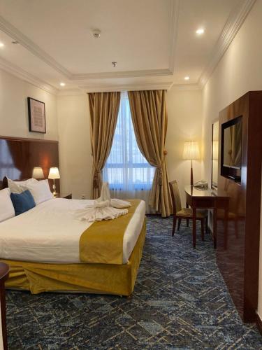 a hotel room with a bed and a desk at فندق بارك رويال in Al Masfalah