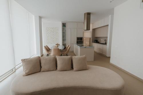 a living room with a couch and a kitchen at MIKU Green Coast in Palasë
