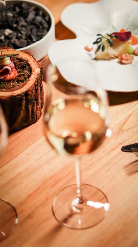 a glass of wine sitting on a wooden table at Boutique Hotel Texel in De Cocksdorp