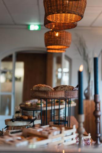 a table with three tiers of pastries and a candle at Boutique Hotel Texel in De Cocksdorp