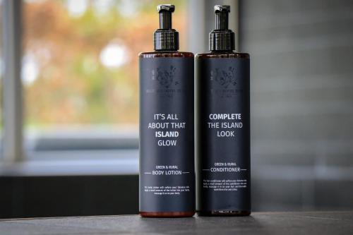 two bottles of shampoo sitting on a table at Boutique Hotel Texel in De Cocksdorp