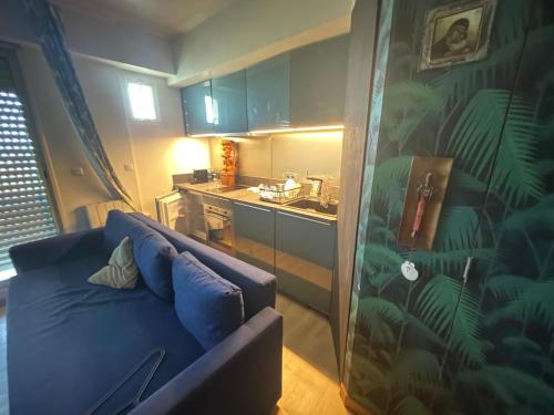 un salon avec un canapé bleu dans une cuisine dans l'établissement Studio sur 2 plages , piscine et 3 personnes, à Biarritz