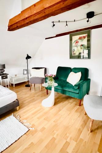 タツィングにあるApartments am Wellenreiter Kuestenwindeの緑のソファとテーブルのあるリビングルーム