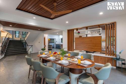 a dining room with a table and chairs at StayVista at Bael Leaf with Projector Setup, Pool in Nashik