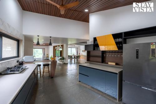 a large kitchen with a counter and a table at StayVista at Bael Leaf with Projector Setup, Pool in Nashik