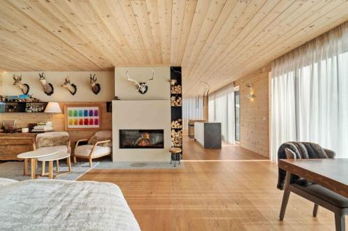 a living room with a wooden ceiling and a fireplace at Chesa Wolf Zuoz in Zuoz