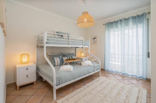 a bedroom with a bunk bed with a lamp and a rug at Bright Flat w/ Terrace & Pools by HostWise in Tavira
