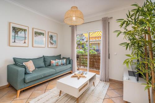 a living room with a green couch and a table at Bright Flat w/ Terrace & Pools by HostWise in Tavira