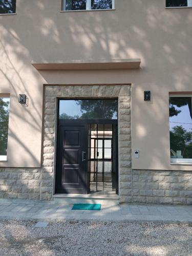 a house with a black door and two windows at Oasi in Larino