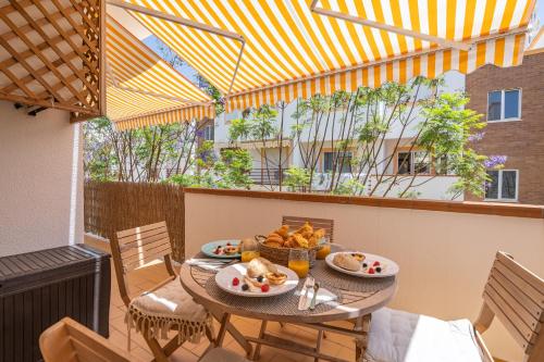 a table with plates of food on a balcony at Bright Flat w/ Terrace & Pools by HostWise in Tavira