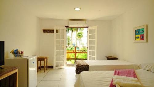 a bedroom with two beds and a door to a patio at Pousada Éden in Angra dos Reis