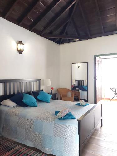a bedroom with a large bed with blue pillows at Casa la plaza in Agulo