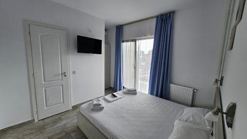 a bedroom with a bed and a large window at Vila duMio in Eforie Nord