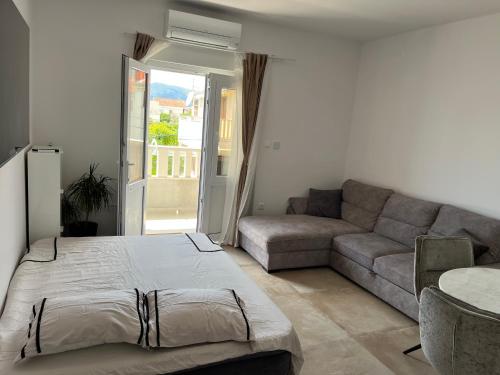 a living room with a bed and a couch at Apartman Sobin 1 in Kaštela