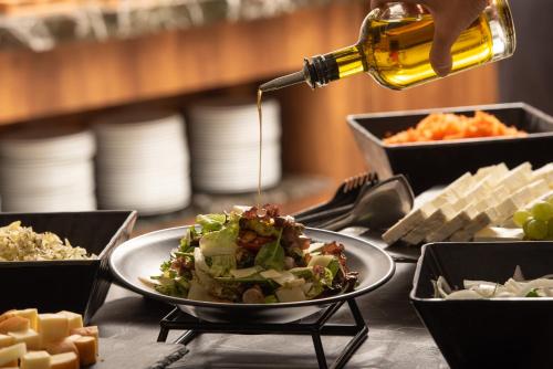 a table with a plate of food and a bottle of wine at Sea Coast Resort Halkidiki in Yerakiní