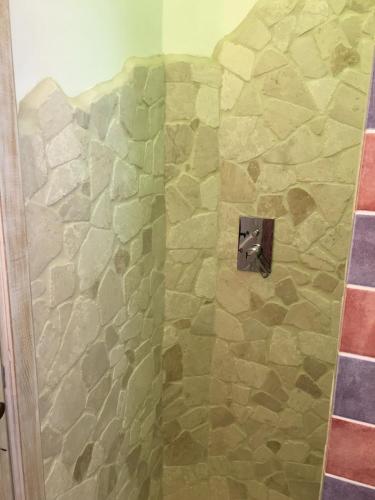 a shower with a stone wall in a bathroom at Monti di Jogliu in Arzachena