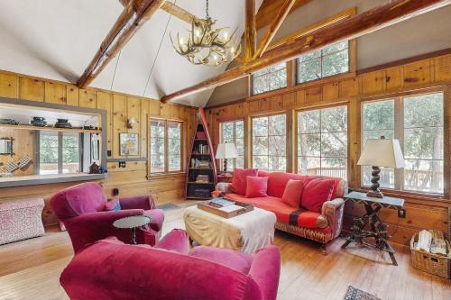 a living room with red furniture and wooden walls at Wildwood Cottage in Idyllwild