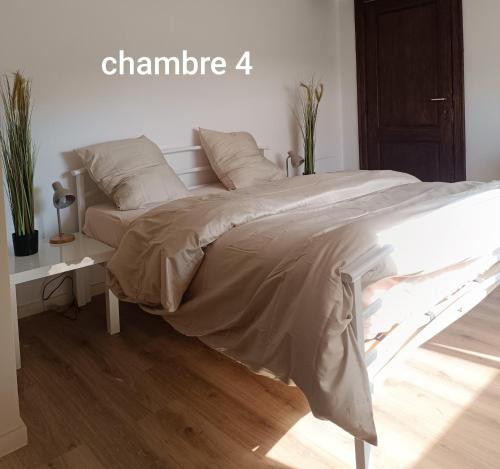 a bed in a white room with a sign that sayschange at La randonnée in Beaumont