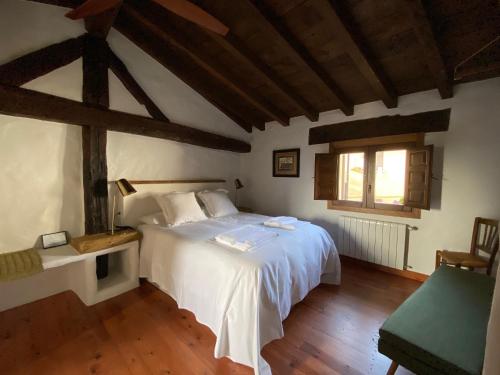 una camera da letto con un letto bianco e una finestra di Lanzaroco, tu casa en La Vera a Valverde de la Vera