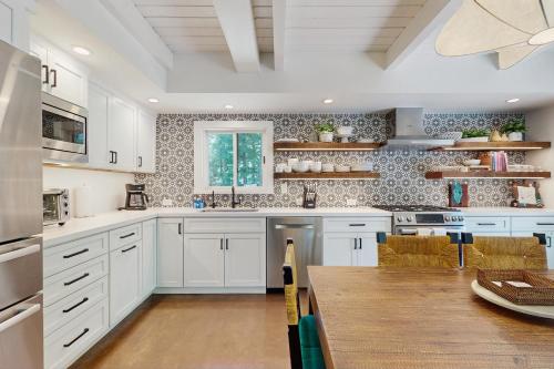 a kitchen with white cabinets and a wooden table at Bearing Drive Escape in Tahoe City