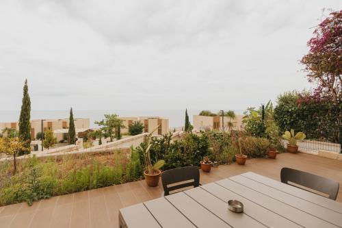 a patio with a table and chairs and plants at MIKU Green Coast in Palasë