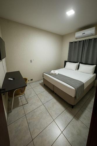 a bedroom with a bed and a table in it at Stallage Hotel in São Pedro