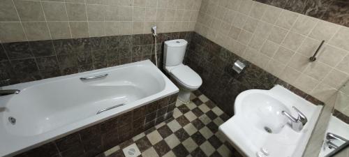 Un baño con un inodoro blanco y un lavabo. en Safeer International Hotel By Brothers International, en Mascate