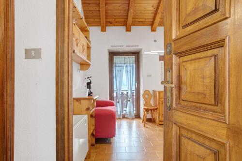 una porta che conduce a un soggiorno con una sedia rossa di Ma Petite Maison ad Aosta
