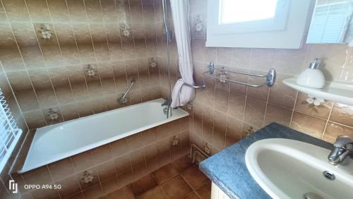 une salle de bain avec une baignoire et un lavabo dans l'établissement Maison des champs et sa grande terrasse privée, à Lourdes